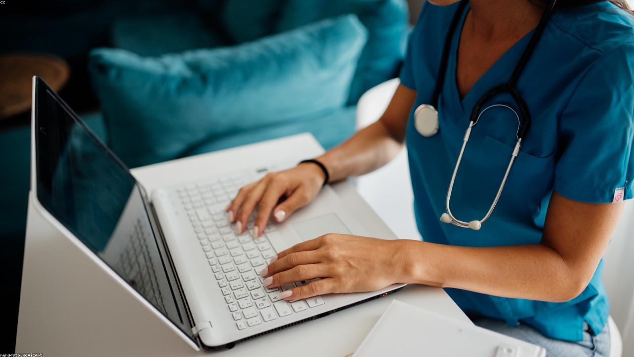Healthcare professional at a workstation with patient education materials.
